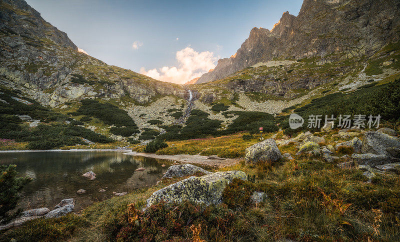 山湖与瀑布和岩石在前景日落。Velicka Valley, High Tatra，斯洛伐克。